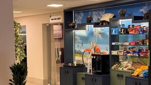 A café with a sign, a bicycle, and shelves stocked with snacks. - Hotel Imperatriz (Telemaco Borba)