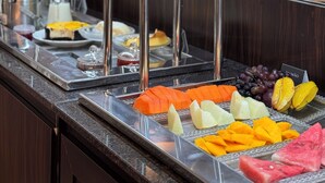 A buffet with various fruits and a coffee station. - Hotel Imperatriz (Telemaco Borba)