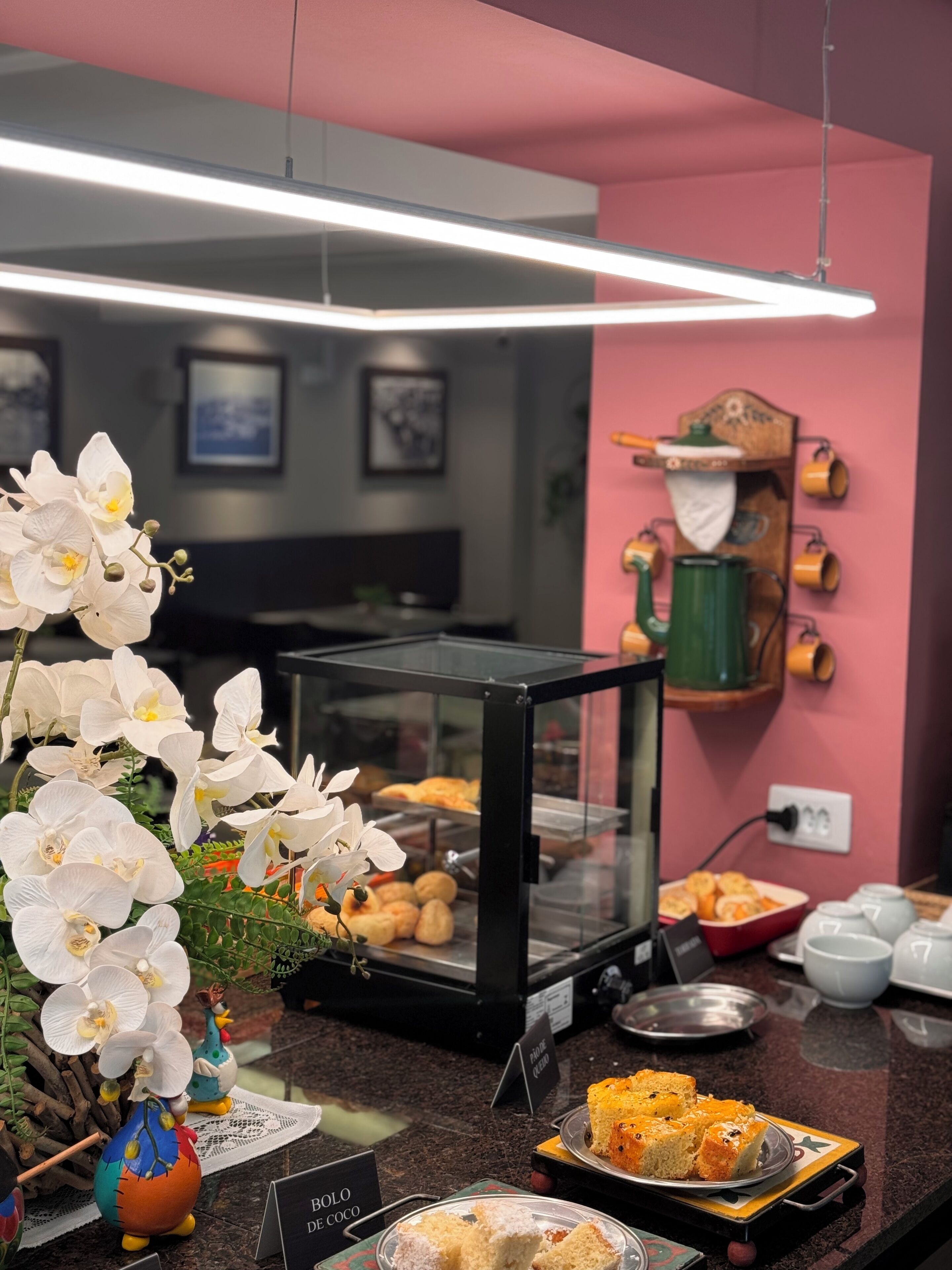 A breakfast buffet with various pastries, a coffee station, and decorative orchids.
