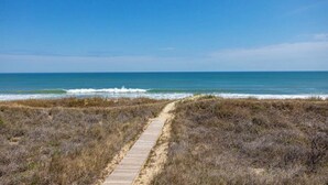 A coastal path leading to the ocean with dry vegetation on either side. - Lawrence, Ships Watch Community in Duck, NC (Duck)