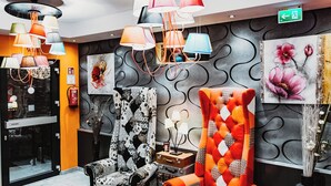 Un hall d’entrée moderne avec un tapis à motifs, un canapé, un fauteuil et une table.