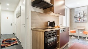 Une cuisine moderne avec des meubles en bois, un four encastré et une machine à café.
