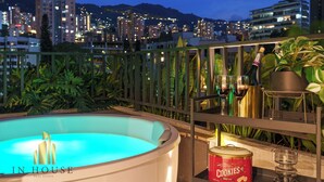 A hot tub on a balcony with a city view, a bottle of wine, and a can of cookies. - Luxe apt in Poblado/AC/BBQ - Morph 1002 (Medellín)