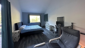 A hotel room with a bed, a desk with a chair, a television, and a window with curtains. - Tranquil Riverfront Retreat Near Tillamook's Best
 (Tillamook)