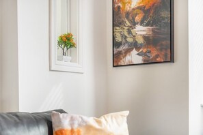 Enjoy a serene space with a window view, framed artwork, and a cozy sofa.