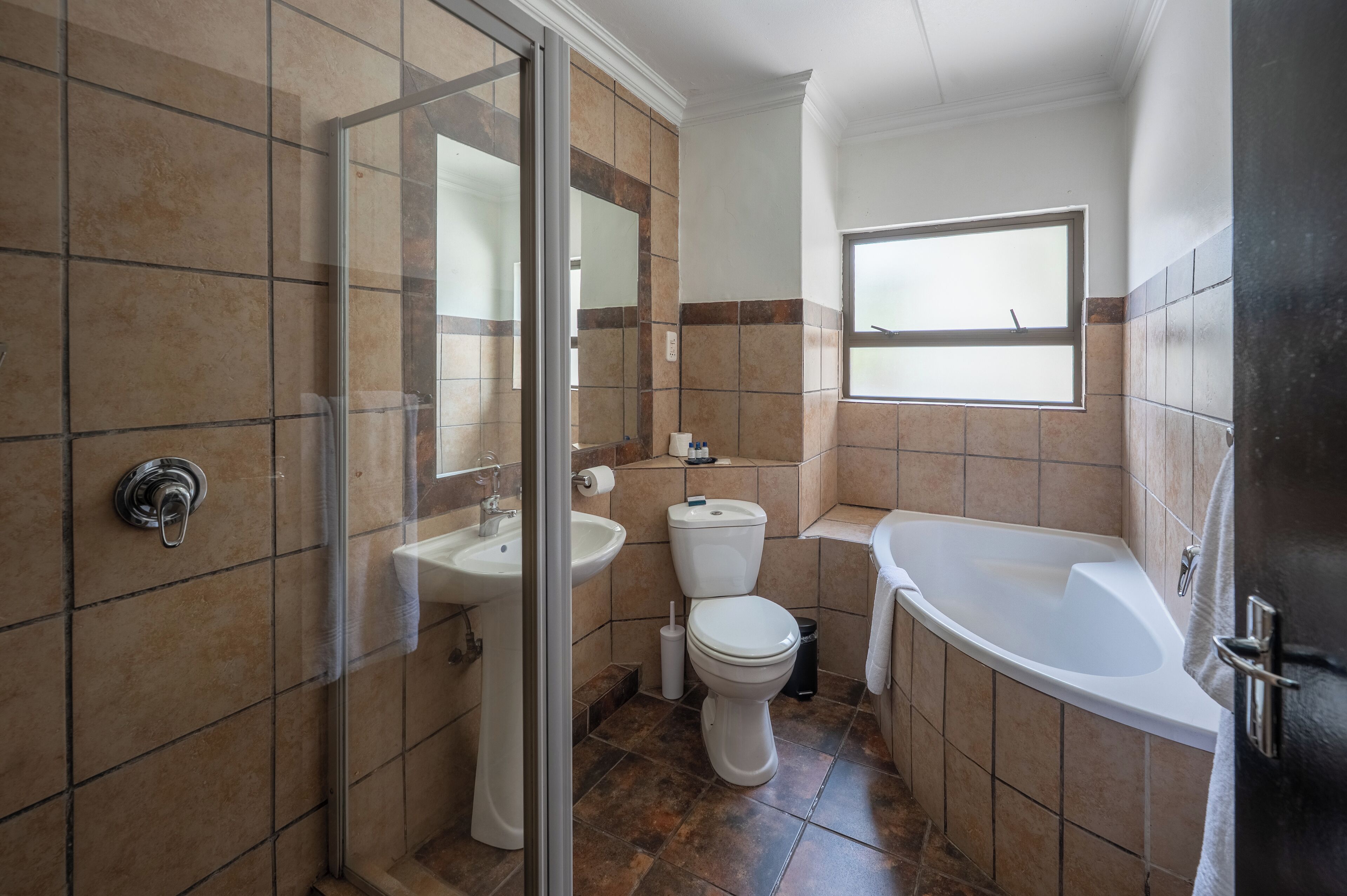 A bathroom with a glass shower enclosure, a sink, toilet, and a bathtub.