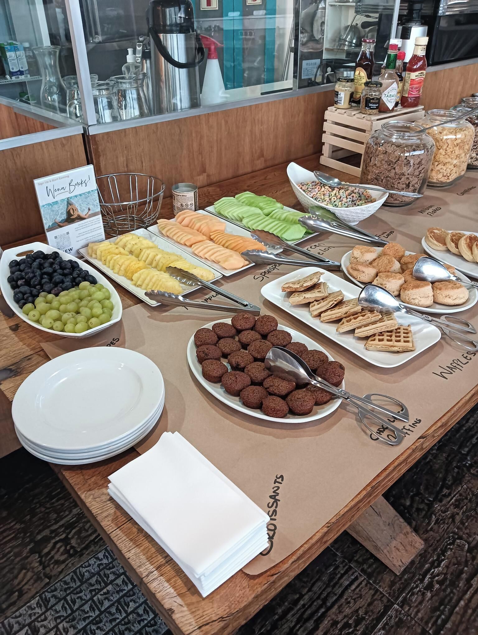 A buffet with various food items including fruits, cereals, and pastries.
