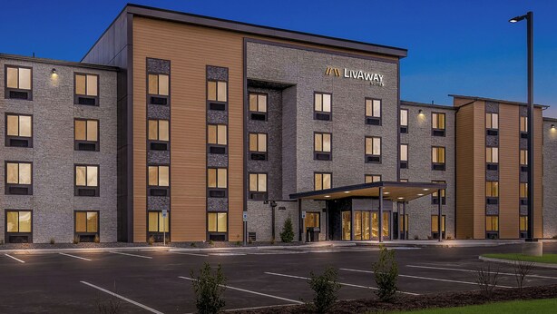 A modern hotel with a stone facade, multiple windows, and a covered entrance. - LivAway Suites Nashville- Smyrna (Smyrna)