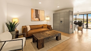 A modern living room with a brown leather sofa, a wooden coffee table, a potted plant, and a large abstract painting on the wall. - LivAway Suites Nashville- Smyrna (Smyrna)