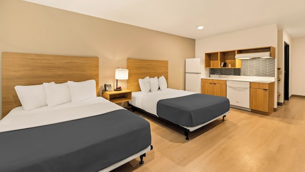 A hotel room with two beds, a kitchenette, and a bathroom. - LivAway Suites Nashville- Smyrna (Smyrna)