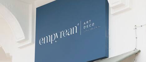 A storefront with a blue sign reading "empyrean ART DECO CONA COLONIAL."