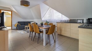 A modern kitchen with a dining area, wooden cabinets, and a dining table with chairs.