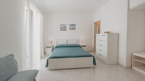 A bedroom with a bed, nightstands, a dresser, and a chair.
