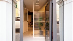 A modern interior with a glass partition, a staircase, and a view of the street outside. - Suite Veronetta (Verona)