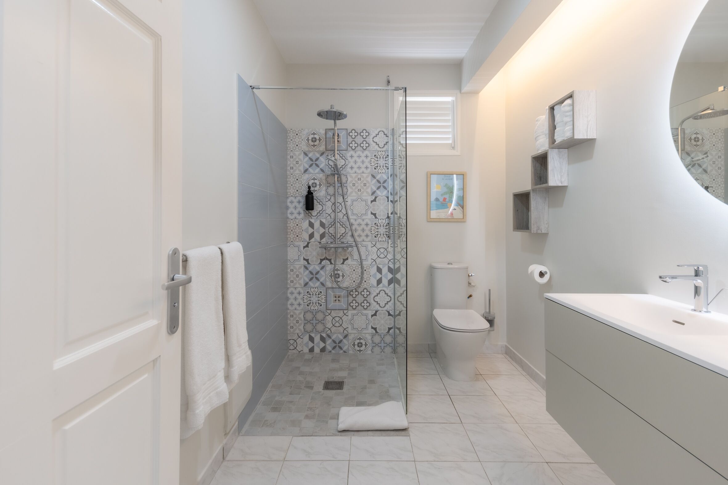 A modern bathroom with a shower, toilet, and vanity.