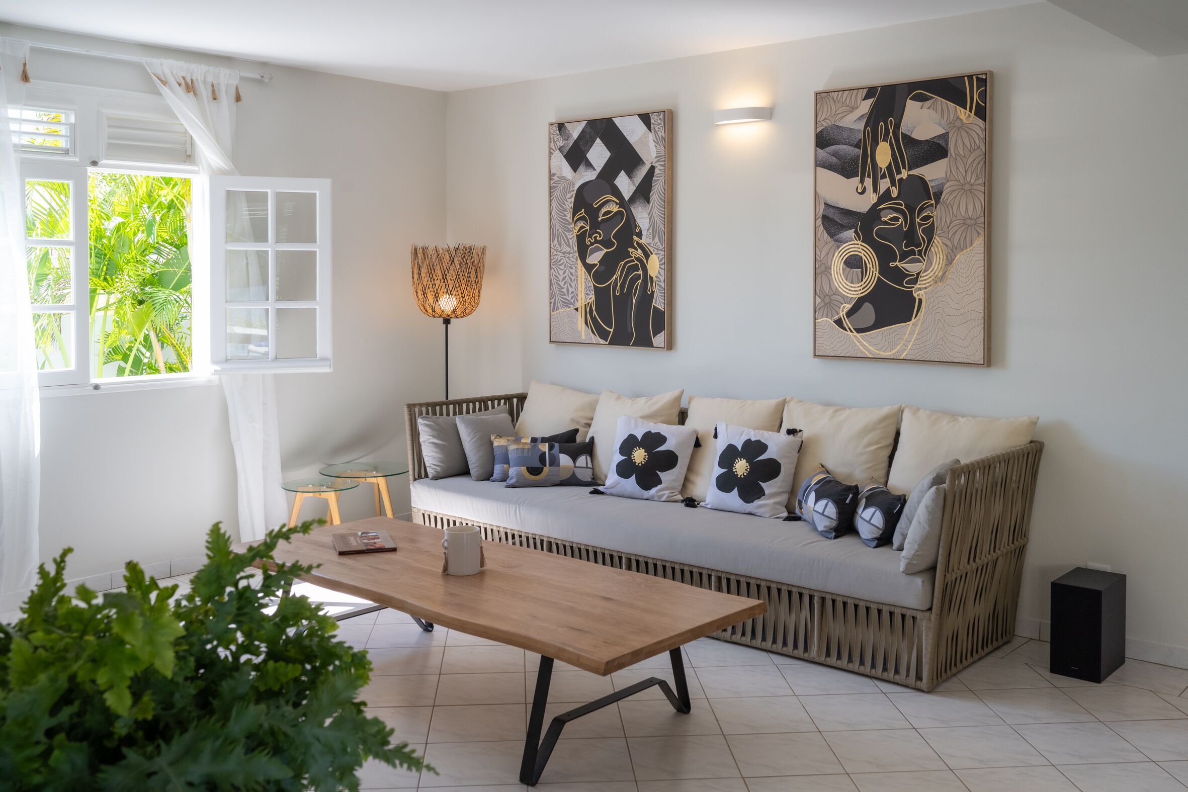 A modern living room with a sofa, a coffee table, and artwork on the walls.