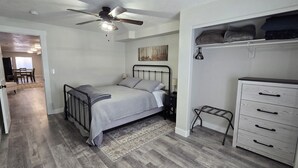 Un dormitorio con cama, cómoda, ventilador de techo y alfombra.