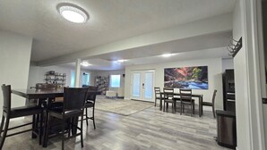 Un salón amplio con comedor, chimenea y un ventanal con vistas a un cañón.