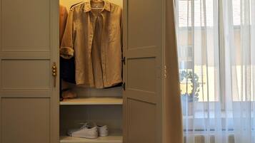 A walk-in closet with hanging clothes and shelves.