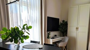 A modern kitchen with a black countertop, a dining table, and a potted plant. - Elegant Studio in the Historic Center, AC, Quiet Area (Sibiu)