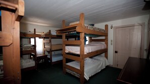 A room with bunk beds, a wooden desk, and a door. - Beaufort Harbour Suites West Lodge (Beaufort)