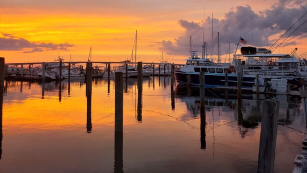 A marina with boats docked at wooden piers during sunset. - Beaufort Harbour Suites West Lodge (Beaufort)