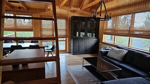 Ein Holzblockhaus-Interieur mit Essbereich, einer Couch und einem Schrank.