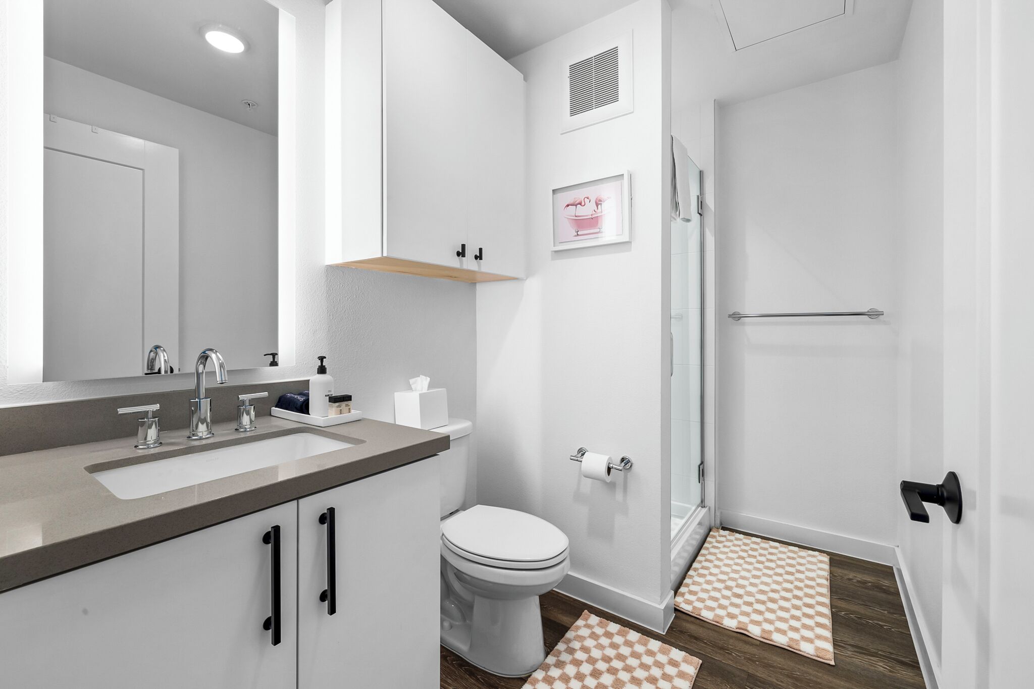 A modern bathroom with a sink, toilet, and shower.