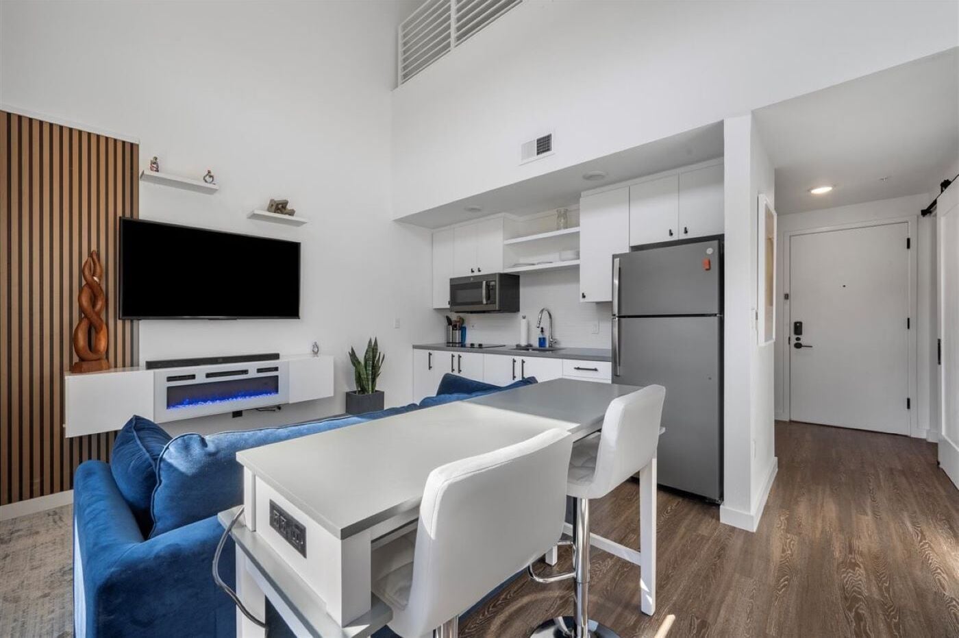 A modern apartment with a living area, kitchen, and dining space.
