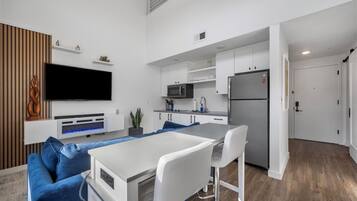 A modern apartment with a living area, kitchen, and dining space.