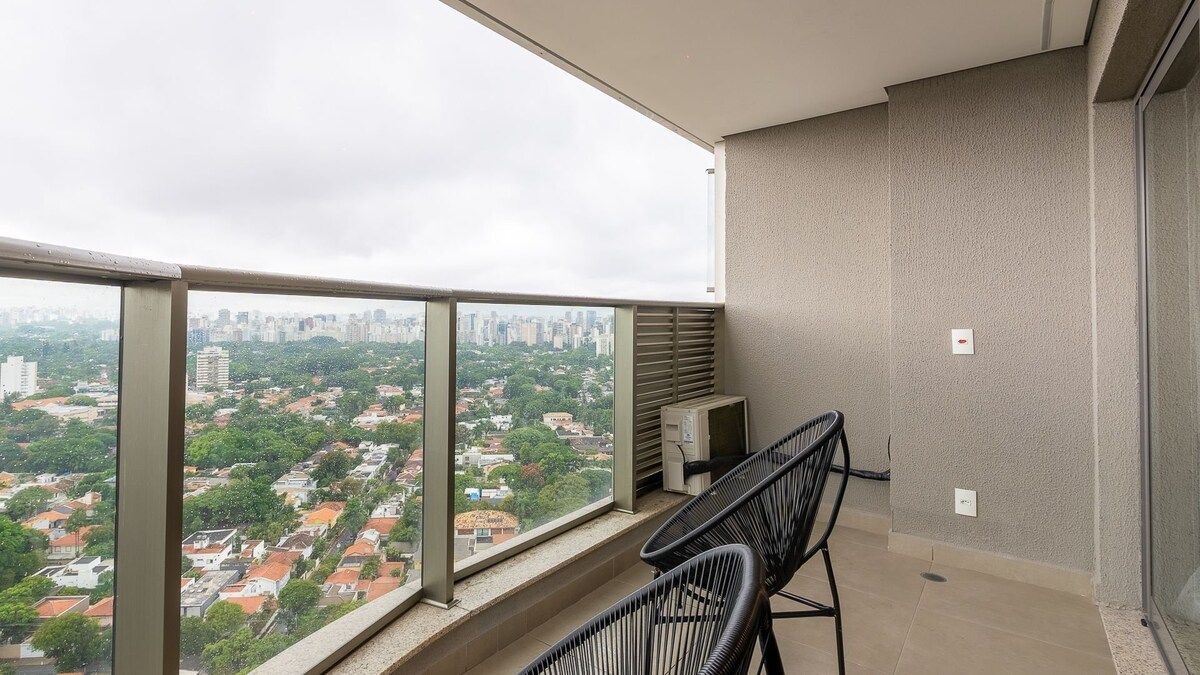 Un balcon avec vue sur la ville, une petite table et deux chaises.