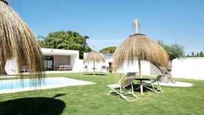 A poolside area with a clear blue sky, a thatched umbrella, and a lounge chair. - Beautiful Villa for 12 Guests – Adults Only (25+) with Private Pool, Wi-Fi & Air Conditioning (Chiclana de la Frontera)