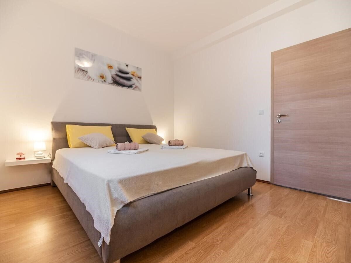 Un dormitorio con cama, mesita de noche y una puerta.