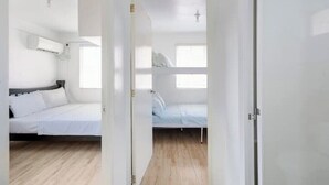 A room with a bed, a window, and a door. - Serene Cozy Air Con Home in Fully-Secured Complex (Urdaneta city)