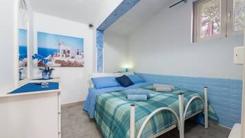 Une chambre à coucher avec un lit, un bureau, un miroir et une fenêtre.