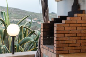A brick oven and a lamp post with a view of a landscape.