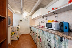 A kitchen with white cabinets, a microwave, a coffee maker, and a tiled backsplash. - Holiday Home 'Casa Montereale' with Sea View, Private Terrace and Wi-Fi (Realmonte)