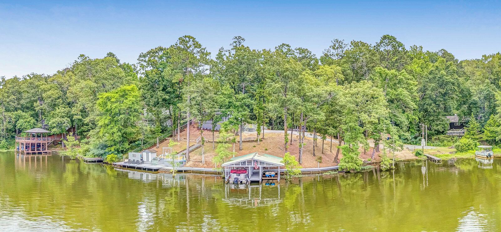 A lakeside property with a dock, a small cabin, and a gazebo.