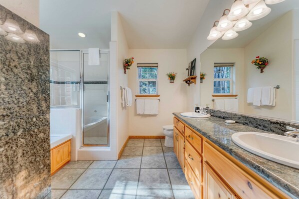 A modern bathroom with a granite countertop, a large sink, wooden cabinets, and a glass shower enclosure. - Tahoe Vista by Avantstay Central Location + Patio (Tahoe Vista)