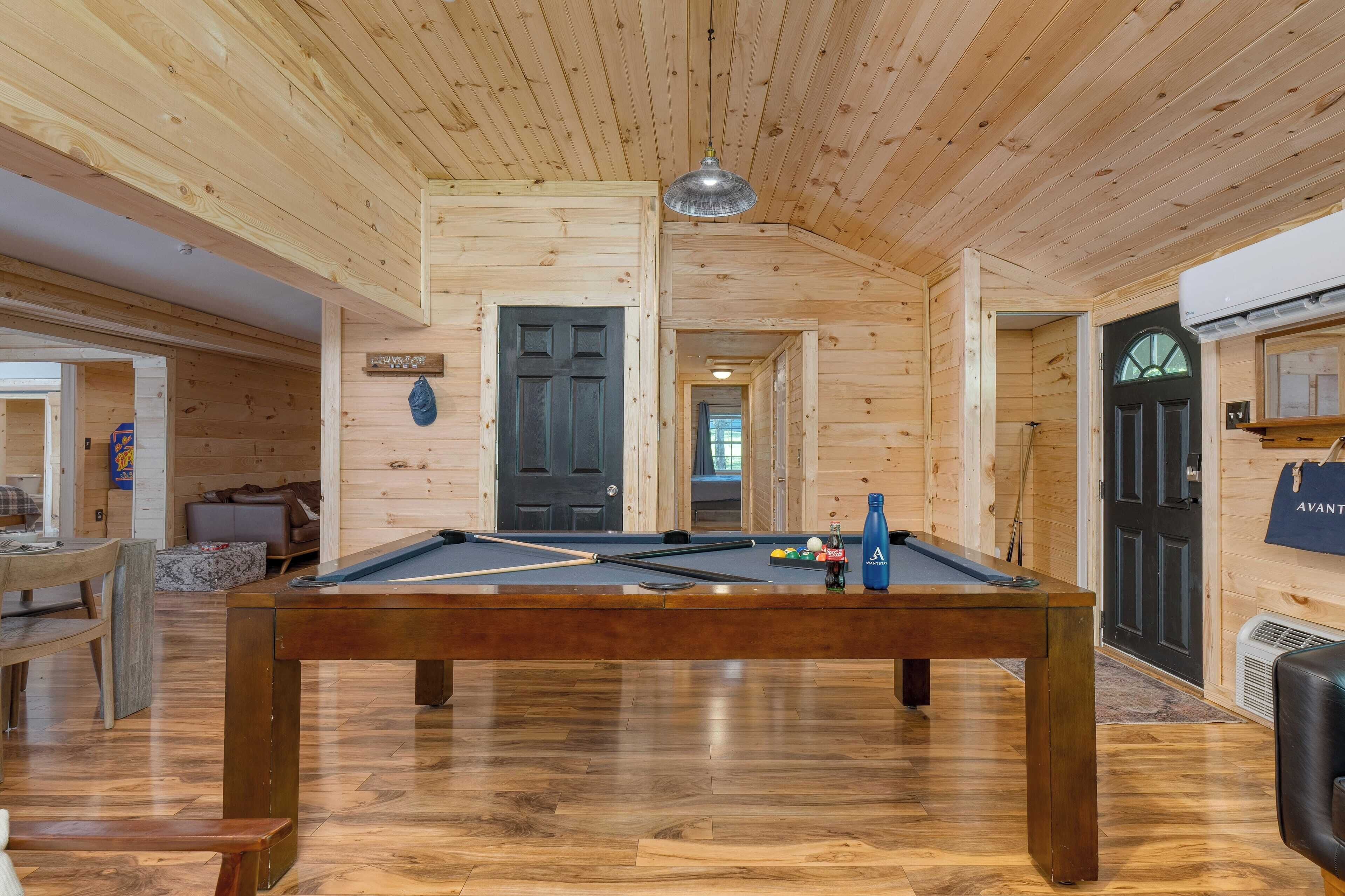 Un interior de madera con una mesa de billar, un sofá y equipo de billard.