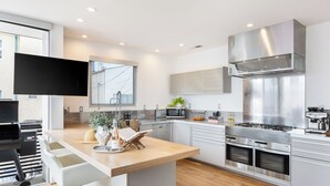 A modern kitchen with a central island, built-in appliances, and a large window. - Venice View by Avantstay Walk to Venice Beach Rooftop, Ice Bath, Luxe Design (Venice)