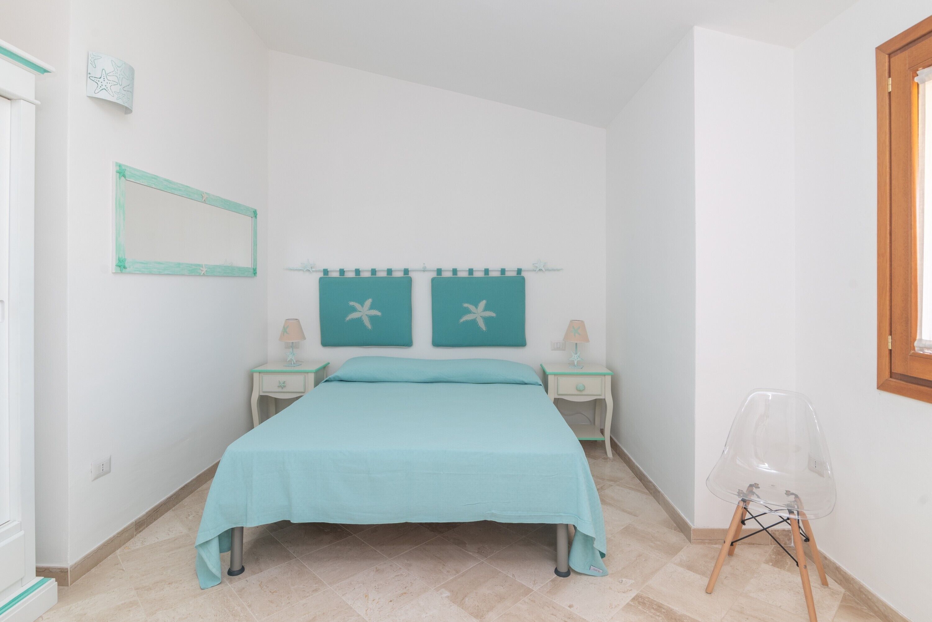 A bedroom with a bed, two nightstands, a chair, a mirror, and star decorations on the wall.
