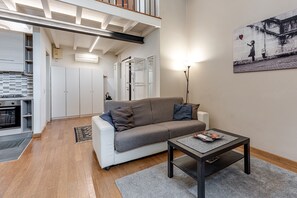 A modern living room with a sofa, coffee table, and artwork on the wall.