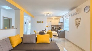 A modern living room with a sofa, dining table, and kitchen area. - Apartment Viola in center of Medulin for 6 person (Medulin)