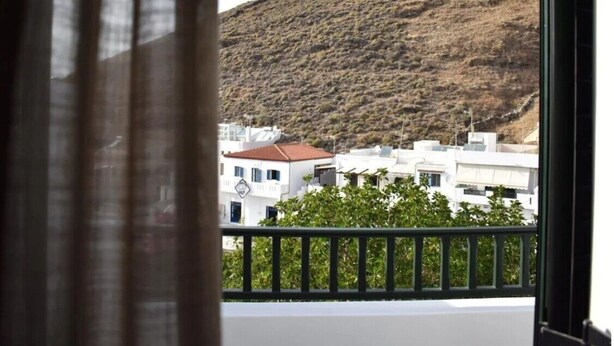 A view from a window with a balcony, overlooking a hillside with buildings. - Apartment 'Manolika Studio 5' with Sea View, Wi-Fi and Air Conditioning (Kythnos)