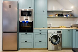 A kitchen with a stainless steel refrigerator, oven, microwave, and washing machine. - Apartment 'Pardo 3' with Private Terrace, Wi-Fi and Air Conditioning (León)