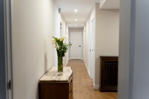 A hallway with a marble-top table, a vase with flowers, and a radiator. - Rural House 'El Capricho Del Tejar' 20 Minutes from León (Cimanes del Tejar)
