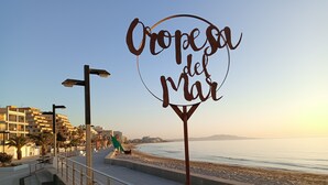 Une promenade en bord de mer avec un panneau indiquant « Oropesa del Mar » et une vue sur la mer.