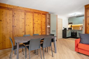 Un espace de vie compact comprenant un coin repas, une kitchenette et un canapé.
