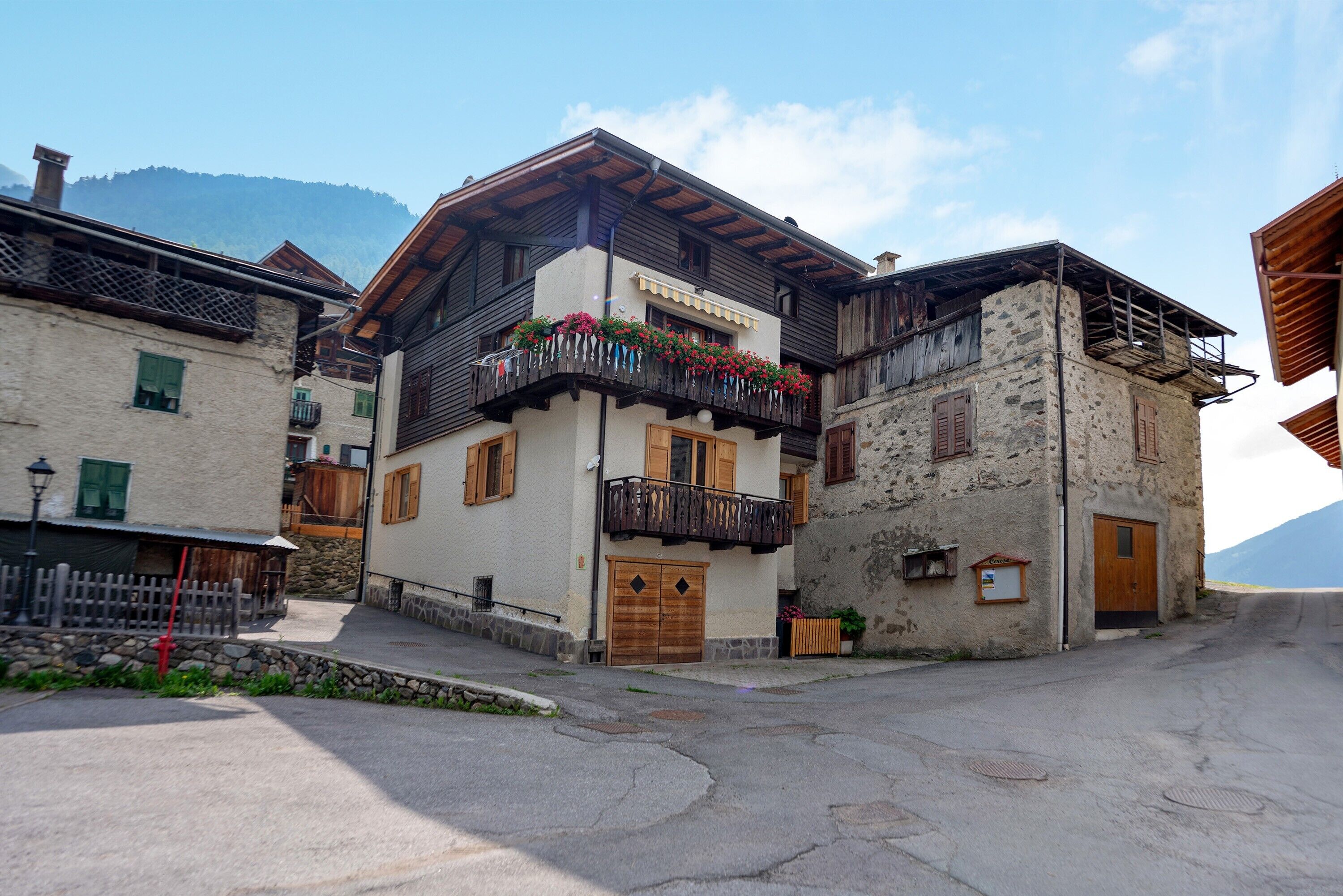 Un bâtiment traditionnel doté d’un balcon, de volets en bois et d’une façade en pierre.